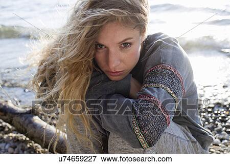 Woman sitting on windy beach View Large Photo Image Stock Photo - Woman sitting on windy beach. Fotosearch