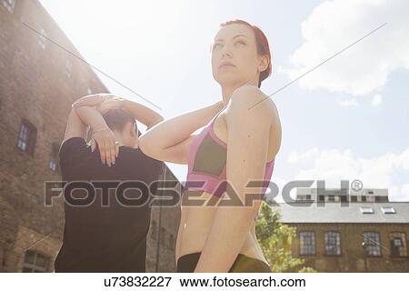 Women doing stretching exercise, building in background, East London, UK View Large Photo Image Stock Photo - Women doing stretching exercise, building in background, East London, UK. Fotosearch