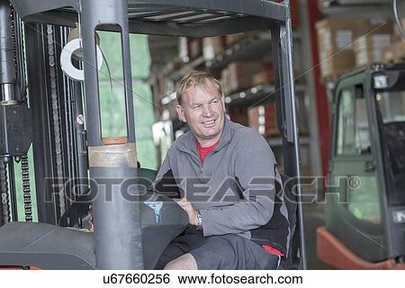 Worker driving forklift truck in hardware store warehouse View Large Photo Image Stock Photograph - Worker driving forklift truck in hardware store warehouse. Fotosearch