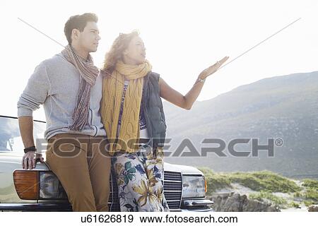 Young couple leaning against car chatting, Cape Town, Western Cape, South Africa View Large Photo Image Stock Photo - Young couple leaning against car chatting, Cape Town, Western Cape, South Africa. Fotosearch