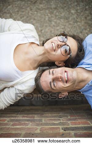 Young couple lying down side by side, high angle View Large Photo Image Stock Image - Young couple lying down side by side, high angle. Fotosearch