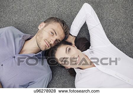 Young couple lying on floor, portrait View Large Photo Image Stock Photo - Young couple lying on floor, portrait. Fotosearch