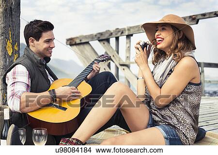 Young couple playing acoustic guitar on old pier, Cape Town, Western Cape, South Africa View Large Photo Image Picture - Young couple playing acoustic guitar on old pier, Cape Town, Western Cape, South Africa. Fotosearch