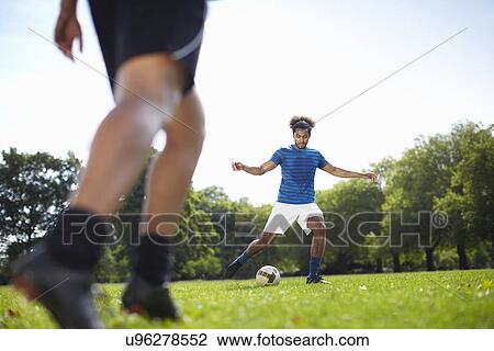 Young couple playing football together in park View Large Photo Image Stock Image - Young couple playing football together in park. Fotosearch