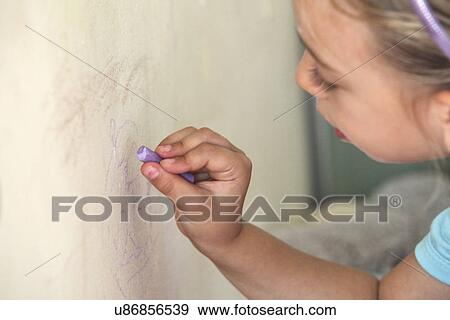 Young girl drawing on wall with chalk View Large Photo Image Stock Photo - Young girl drawing on wall with chalk. Fotosearch