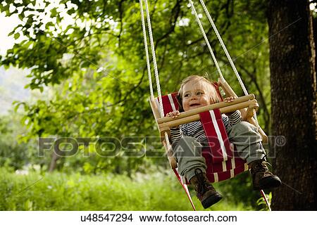 Young girl in swing, smiling View Large Photo Image Picture - Young girl in swing, smiling. Fotosearch