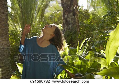 Young girl looking up at trees View Large Photo Image Stock Image - Young girl looking up at trees. Fotosearch