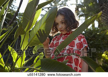 Young girl, pensive expression, standing amongst foliage View Large Photo Image Stock Image - Young girl, pensive expression, standing amongst foliage. Fotosearch