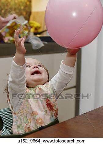 Picture - Young girl playing with balloon. Fotosearch