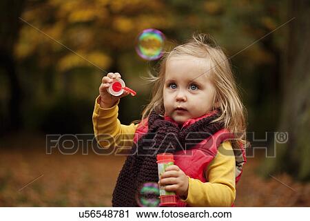 Young girl playing with bubble wand View Large Photo Image Stock Image - Young girl playing with bubble wand. Fotosearch