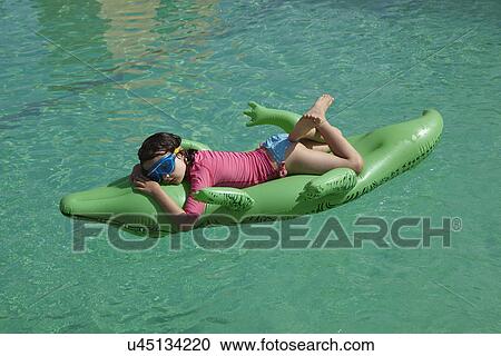 Young girl relaxing on inflatable in swimming pool View Large Photo Image Stock Image - Young girl relaxing on inflatable in swimming pool. Fotosearch