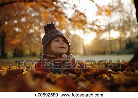 Young girl sitting in autumn leaves View Large Photo Image Stock Image - Young girl sitting in autumn leaves. Fotosearch