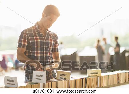 Young man at second hand book stall View Large Photo Image Stock Image - Young man at second hand book stall. Fotosearch