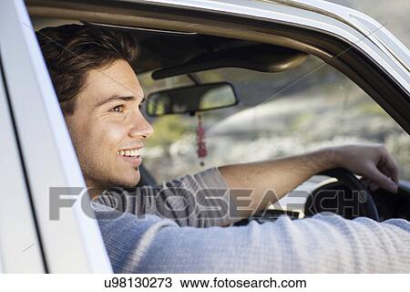 Stock Image - Young man looking from car window, Cape Town, Western Cape, South Africa. Fotosearch