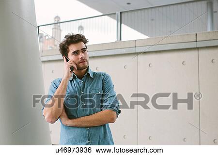 Stock Photograph - Young man on cell phone. Fotosearch
