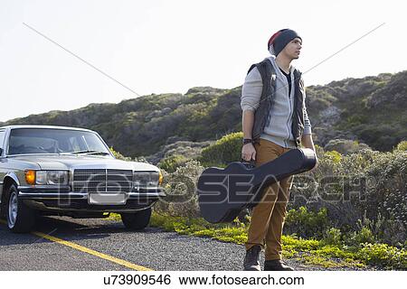 Young man on roadside with guitar case, Cape Town, Western Cape, South Africa View Large Photo Image Stock Photograph - Young man on roadside with guitar case, Cape Town, Western Cape, South Africa. Fotosearch