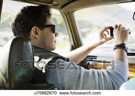 Young man photographing through windscreen, Cape Town, Western Cape, South Africa View Large Photo Image Stock Image - Young man photographing through windscreen, Cape Town, Western Cape, South Africa. Fotosearch