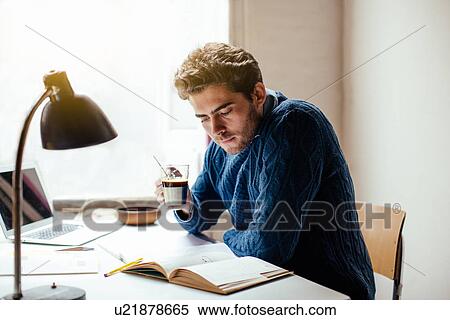 Young man reading book with coffee View Large Photo Image Stock Photography - Young man reading book with coffee. Fotosearch