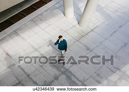 Young man using cell phone, high angle View Large Photo Image Stock Photo - Young man using cell phone, high angle. Fotosearch