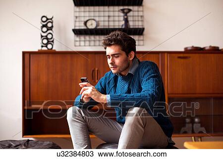 Young man using cell phone View Large Photo Image Stock Image - Young man using cell phone. Fotosearch