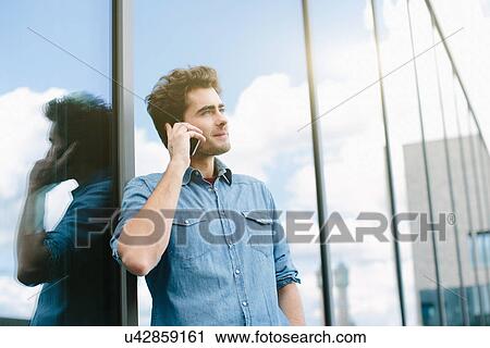 Stock Image - Young man using cell phone. Fotosearch