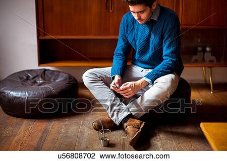Young man using cell phone View Large Photo Image Stock Image - Young man using cell phone. Fotosearch
