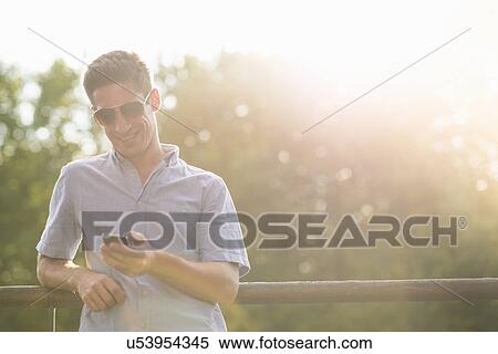 Stock Photography - Young man using cell phone. Fotosearch