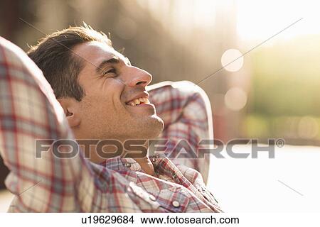 Young man wearing checked shirt, smiling View Large Photo Image Picture - Young man wearing checked shirt, smiling. Fotosearch