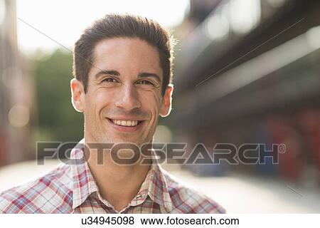Young man wearing checked shirt, smiling View Large Photo Image Stock Photo - Young man wearing checked shirt, smiling. Fotosearch