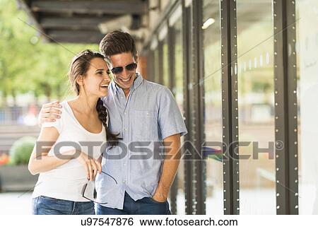 Stock Photograph - Young man with arm around woman, smiling. Fotosearch