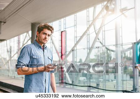 Stock Image - Young man with cell phone. Fotosearch