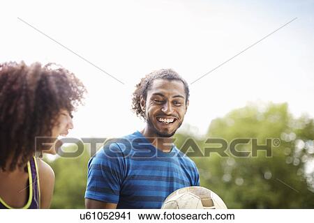 Young soccer couple chatting and laughing together in park View Large Photo Image Stock Image - Young soccer couple chatting and laughing together in park. Fotosearch