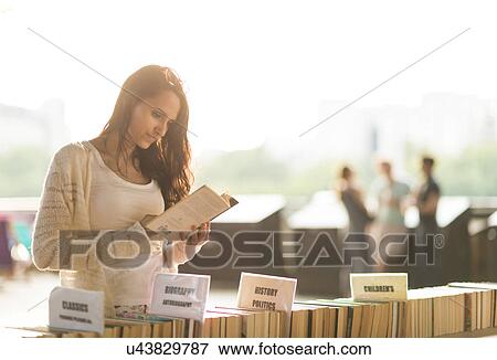 Stock Photo - Young woman at second hand book stall. Fotosearch