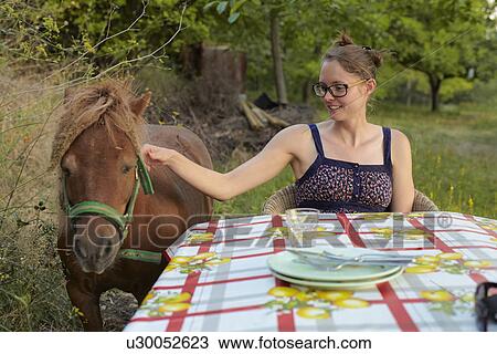 Young woman at table petting pony, Sierra Nevada, Andalucia Granada, Spain View Large Photo Image Stock Image - Young woman at table petting pony, Sierra Nevada, Andalucia Granada, Spain. Fotosearch