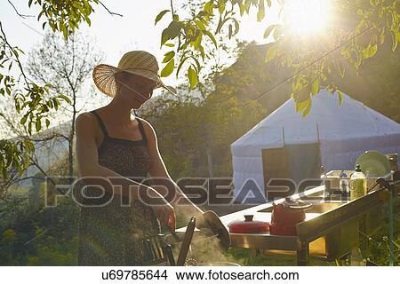 Picture - Young woman cooking food whilst glamping, Sierra Nevada, Andalucia Granada, Spain. Fotosearch