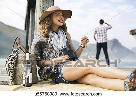 Young woman drinking wine on coastal pier, Cape Town, Western Cape, South Africa View Large Photo Image Stock Photo - Young woman drinking wine on coastal pier, Cape Town, Western Cape, South Africa. Fotosearch