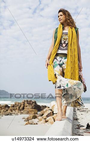 Young woman gazing from cement block on beach, Cape Town, Western Cape, South Africa View Large Photo Image Picture - Young woman gazing from cement block on beach, Cape Town, Western Cape, South Africa. Fotosearch