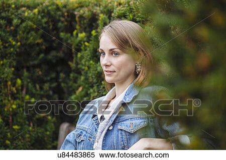Young woman gazing from park bench View Large Photo Image Stock Photography - Young woman gazing from park bench. Fotosearch