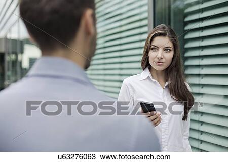 Young woman holding smartphone View Large Photo Image Stock Image - Young woman holding smartphone. Fotosearch