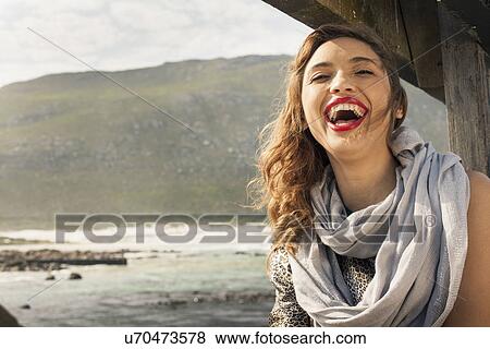 Stock Photo - Young woman laughing on coastal pier, Cape Town, Western Cape, South Africa. Fotosearch