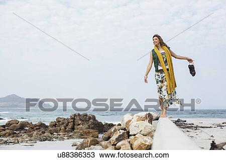 Young woman walking on cement block on beach, Cape Town, Western Cape, South Africa View Large Photo Image Stock Image - Young woman walking on cement block on beach, Cape Town, Western Cape, South Africa. Fotosearch
