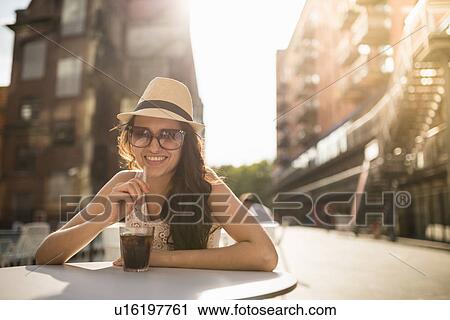 Young woman wearing hat and sunglasses with drink View Large Photo Image Stock Image - Young woman wearing hat and sunglasses with drink. Fotosearch