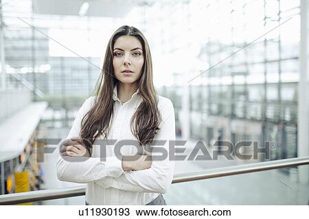 Stock Image - Young woman wearing white shirt, portrait. Fotosearch