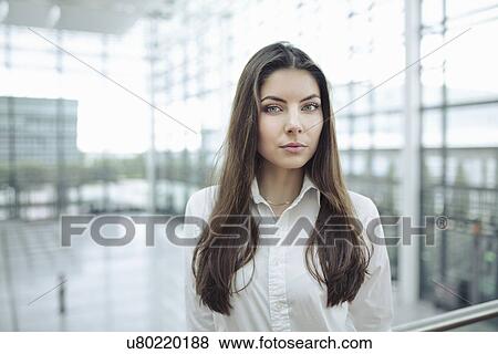 Stock Photo - Young woman wearing white shirt, portrait. Fotosearch