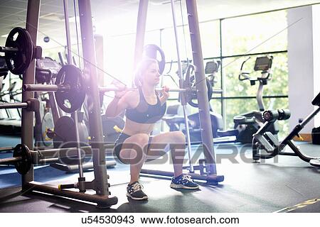 Young woman weight lifting with barbell View Large Photo Image Stock Image - Young woman weight lifting with barbell. Fotosearch