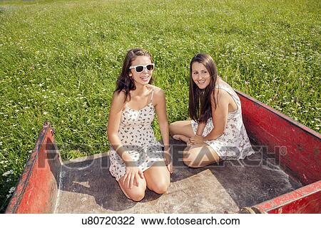 Young women sitting in trailer View Large Photo Image Stock Image - Young women sitting in trailer. Fotosearch