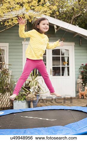 Stock Photograph - Girl bouncing on a trampoline. Fotosearch