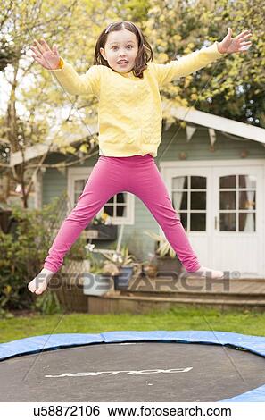 Girl bouncing on a trampoline View Large Photo Image Stock Photograph - Girl bouncing on a trampoline. Fotosearch