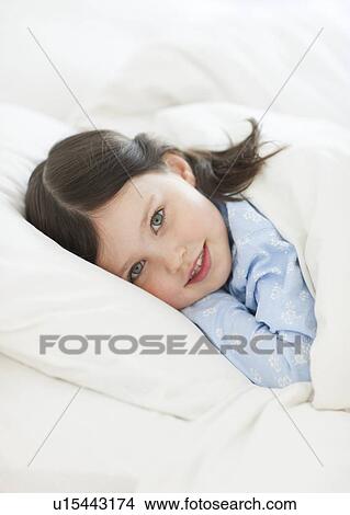 Girl lying in bed View Large Photo Image Picture - Girl lying in bed. Fotosearch