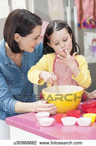 Stock Image - Mother and daughter baking. Fotosearch